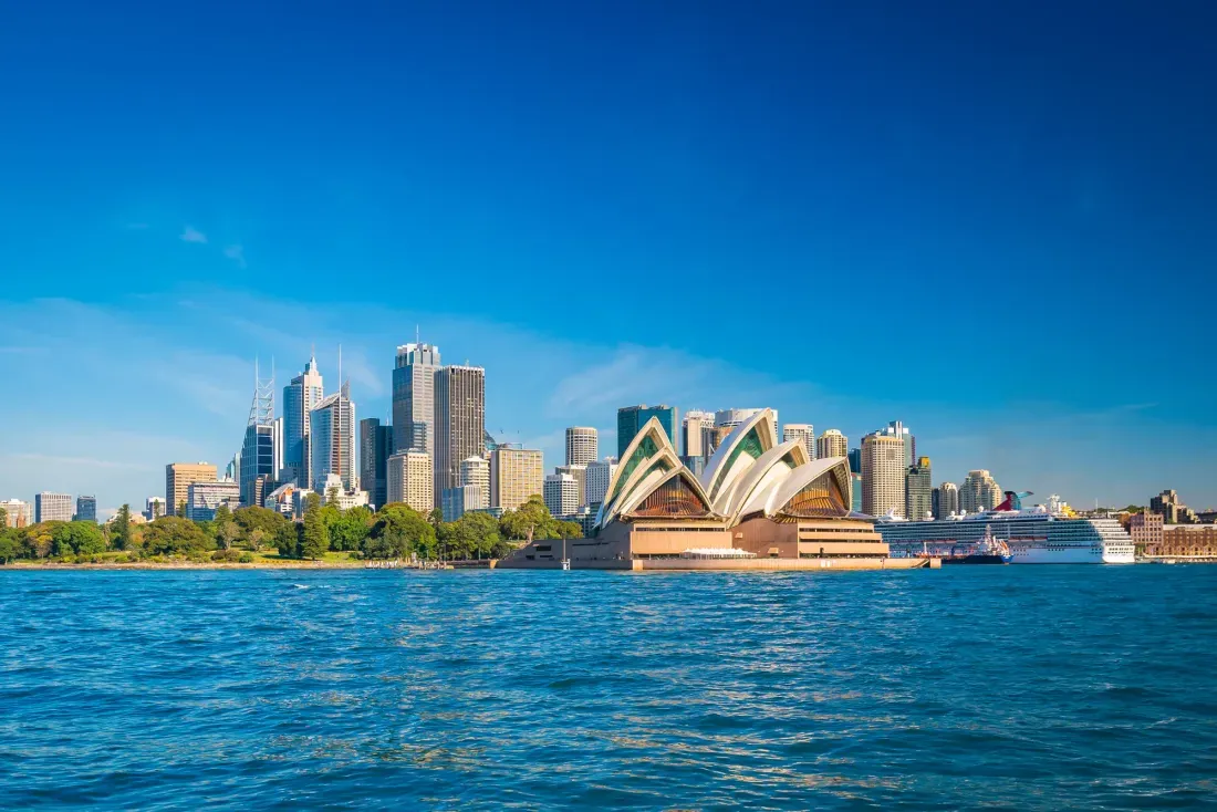 Baía de Sydney com a Opera House e os prédios do centro sob céu azul